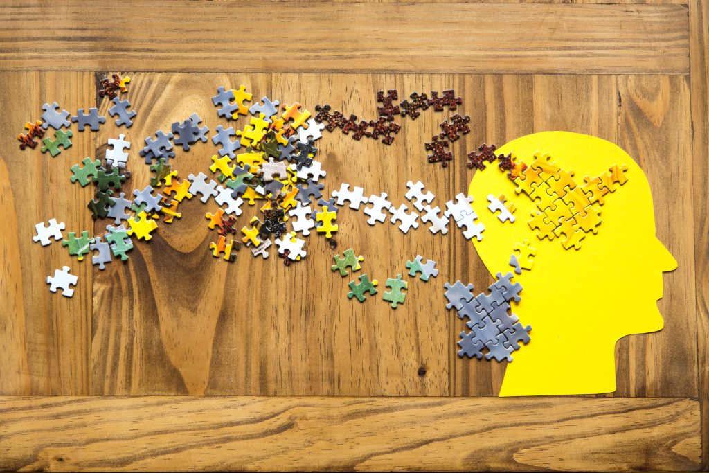 Puzzleteile fügen sich in einem gelben Kopf zusammen – Symbol für Klarheit